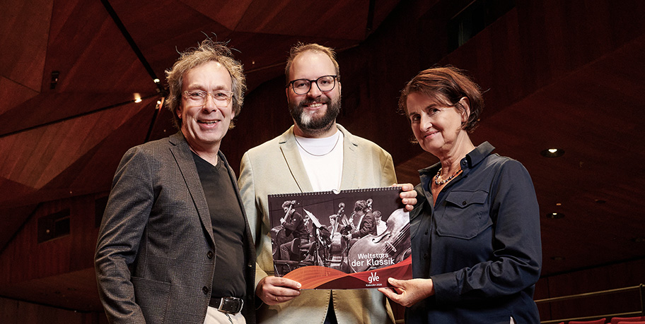 Jürgen Hinterleithner, Julian Fischer und Sabine Kreimendahl halten stolz den neuen gVe-Kalender 2026 in der Heinrich-Lades-Halle in die Kamera